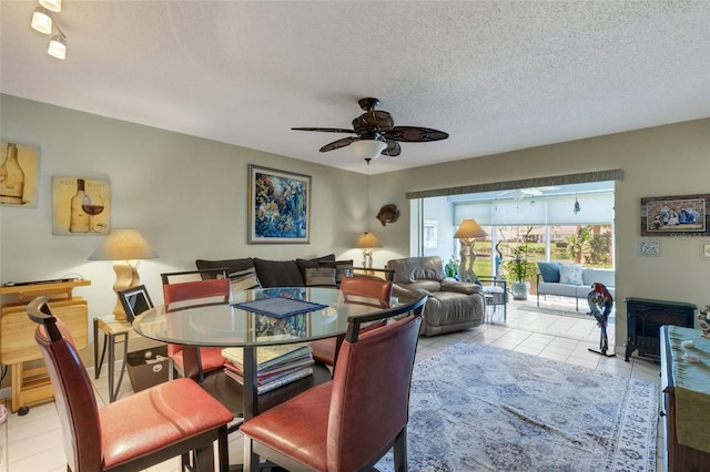 dining space with a textured ceiling, ceiling fan, and light tile patterned floors