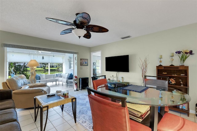 living area with ceiling fan, light tile patterned floors, a textured ceiling, and visible vents