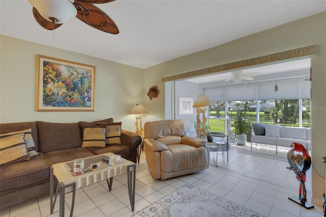 living area featuring a textured ceiling, light tile patterned flooring, and a ceiling fan