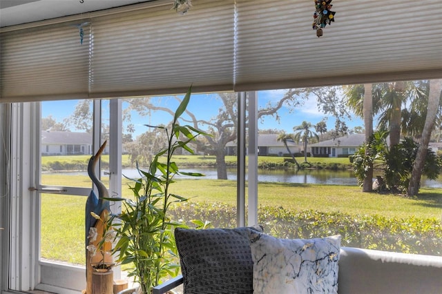 sunroom featuring a water view