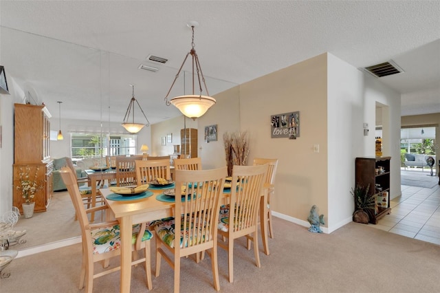 dining area featuring a wealth of natural light, visible vents, and light colored carpet