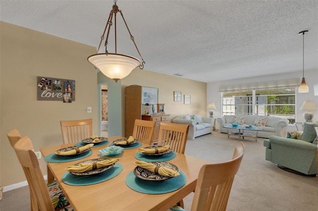 carpeted dining space featuring baseboards and a textured ceiling