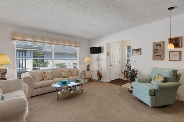 carpeted living area with a textured ceiling and baseboards