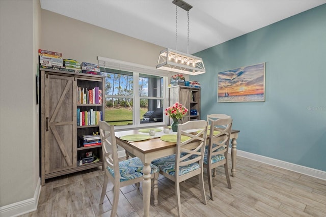 dining room with baseboards and wood finished floors