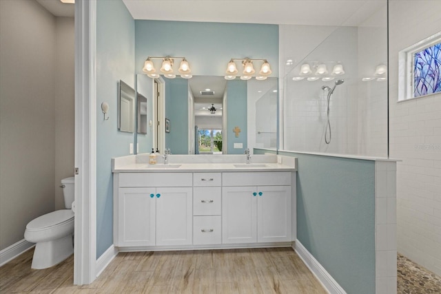 full bathroom with double vanity, a sink, toilet, and a walk in shower