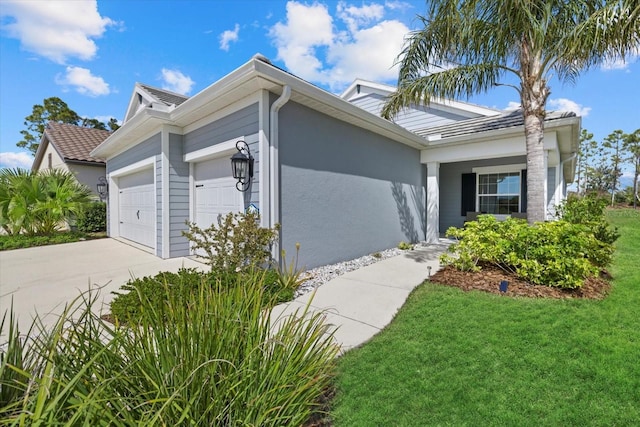 view of front facade with an attached garage, a front yard, concrete driveway, and stucco siding