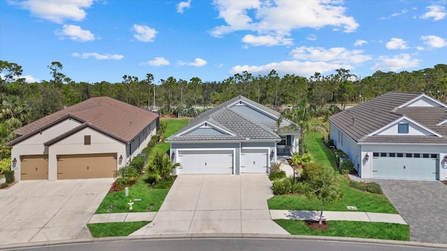 view of front of house featuring a tile roof, driveway, and an attached garage