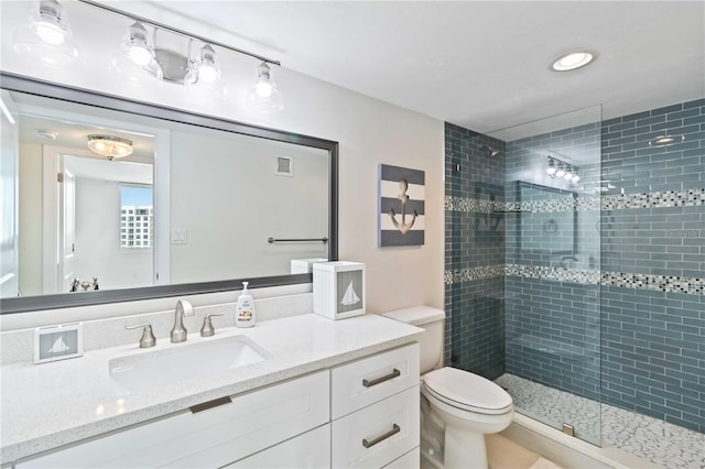 bathroom with toilet, a shower stall, visible vents, and vanity