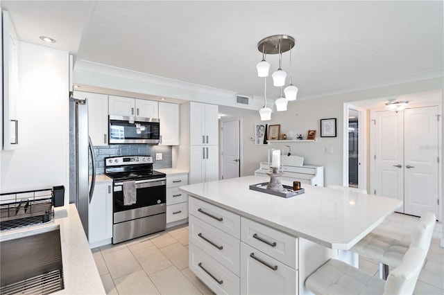 kitchen featuring visible vents, white cabinets, appliances with stainless steel finishes, a center island, and backsplash