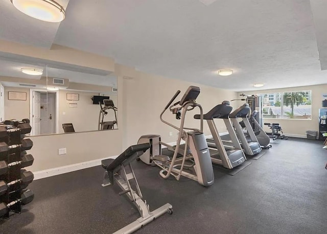 gym with visible vents, baseboards, and a textured ceiling