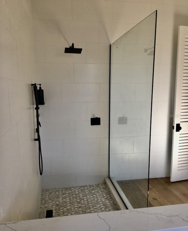 full bathroom with wood finished floors and walk in shower