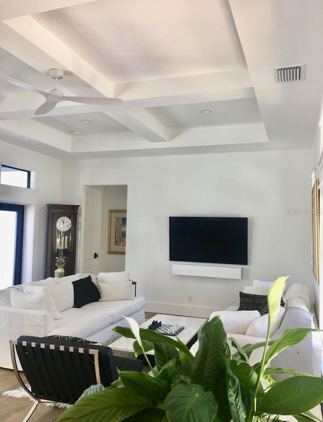 living area with beam ceiling, visible vents, and a ceiling fan