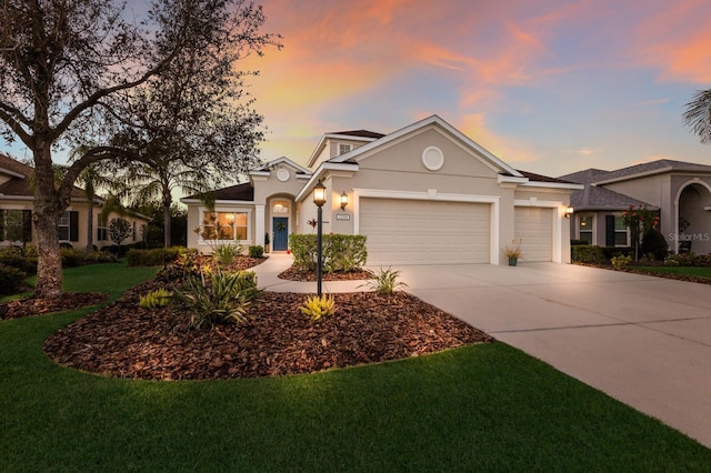 view of front facade with a garage, a front lawn, concrete driveway, and stucco siding