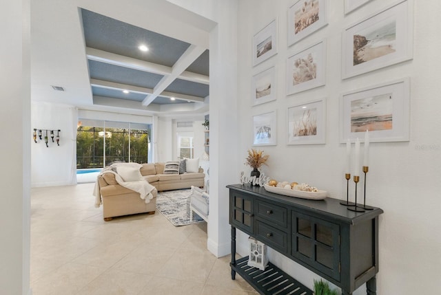 interior space with baseboards, coffered ceiling, beam ceiling, and light tile patterned flooring