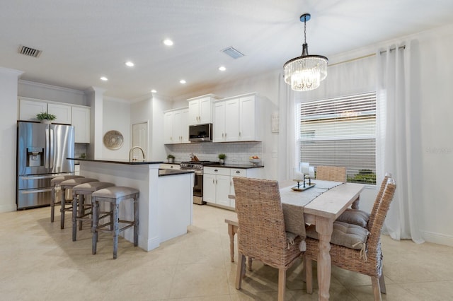 kitchen with appliances with stainless steel finishes, dark countertops, visible vents, and backsplash