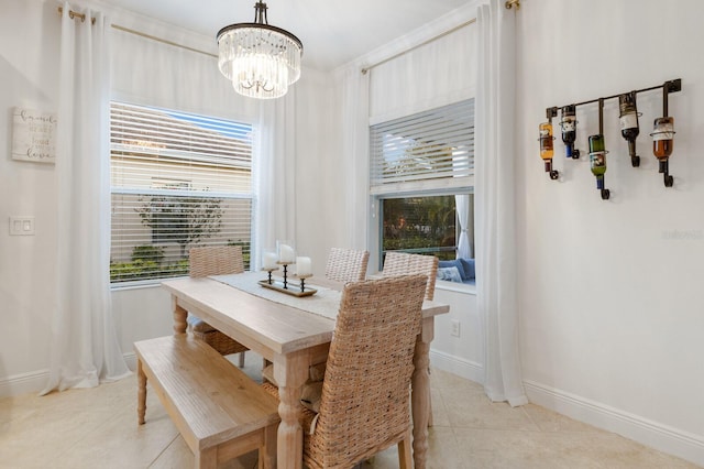 dining area with light tile patterned floors, a chandelier, and baseboards