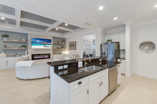 kitchen with white cabinets, coffered ceiling, dark stone counters, stainless steel appliances, and a sink