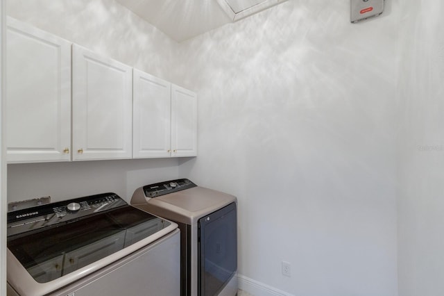 clothes washing area featuring cabinet space, baseboards, and washer and dryer