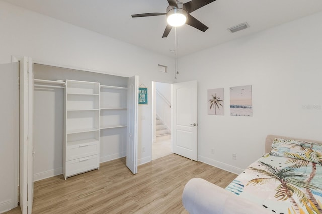 bedroom with light wood-style floors, baseboards, visible vents, and ceiling fan