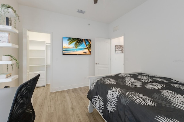 bedroom featuring light wood-style floors, visible vents, and baseboards