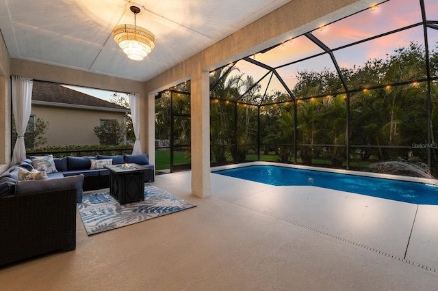 pool at dusk with an outdoor hangout area, a patio, ceiling fan, and a lanai