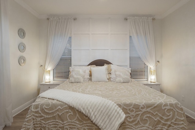 bedroom featuring baseboards, crown molding, and wood finished floors