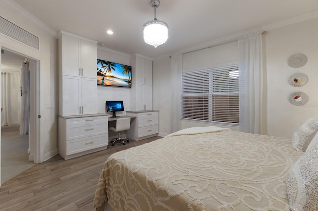 bedroom featuring baseboards, built in desk, light wood-type flooring, and crown molding