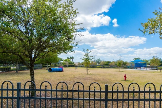 view of property's community featuring fence and a lawn