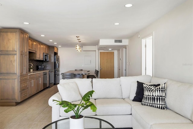 living area featuring light tile patterned flooring, visible vents, and recessed lighting