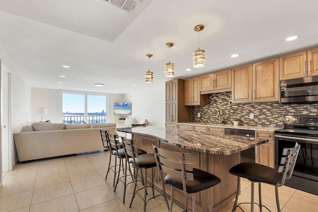 kitchen with stainless steel appliances, open floor plan, visible vents, and backsplash