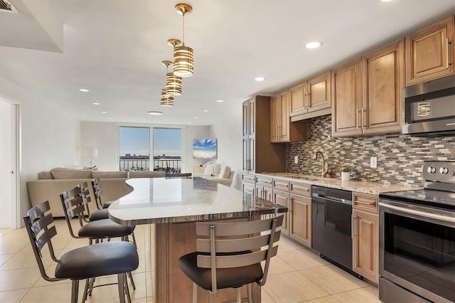 kitchen with appliances with stainless steel finishes, light tile patterned floors, decorative backsplash, and a kitchen bar