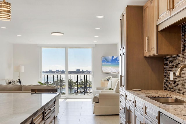 kitchen with expansive windows, open floor plan, a sink, and decorative backsplash