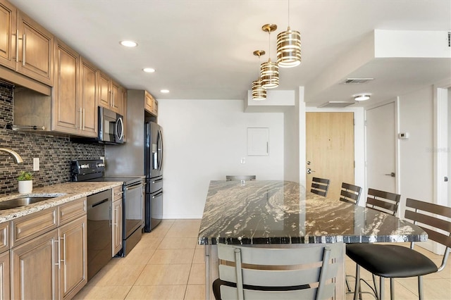 kitchen with a center island, a breakfast bar area, tasteful backsplash, appliances with stainless steel finishes, and a sink