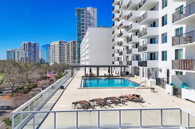 pool featuring a view of city, a patio, and fence