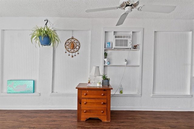 room details featuring a textured ceiling, wood finished floors, a ceiling fan, and baseboards