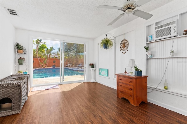 sunroom featuring visible vents, ceiling fan, and a wall mounted AC