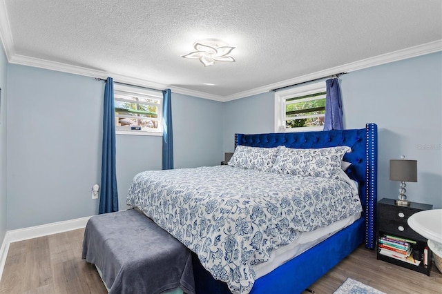 bedroom featuring a textured ceiling, multiple windows, ornamental molding, and wood finished floors