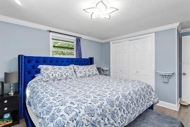 bedroom with baseboards, ornamental molding, wood finished floors, a textured ceiling, and a closet