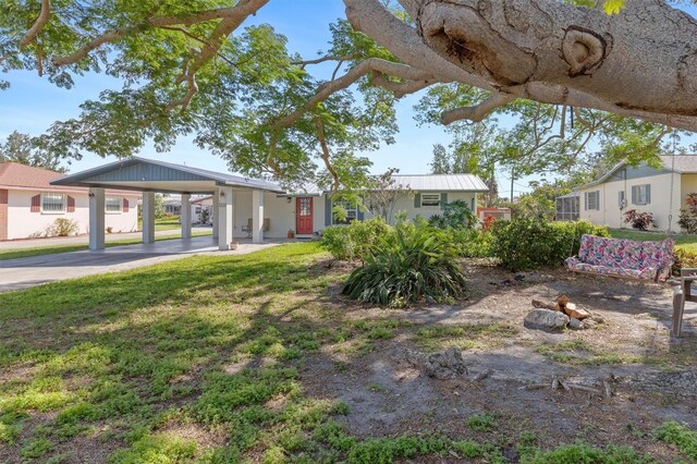 view of yard with concrete driveway and an attached carport