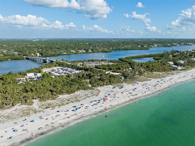 birds eye view of property with a view of the beach, a water view, and a wooded view