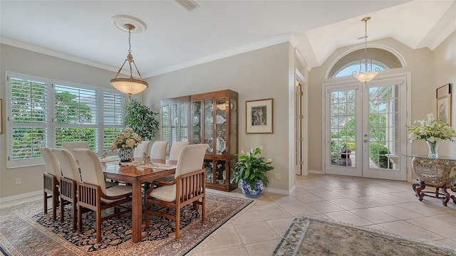 dining area with light tile patterned floors, baseboards, vaulted ceiling, french doors, and crown molding