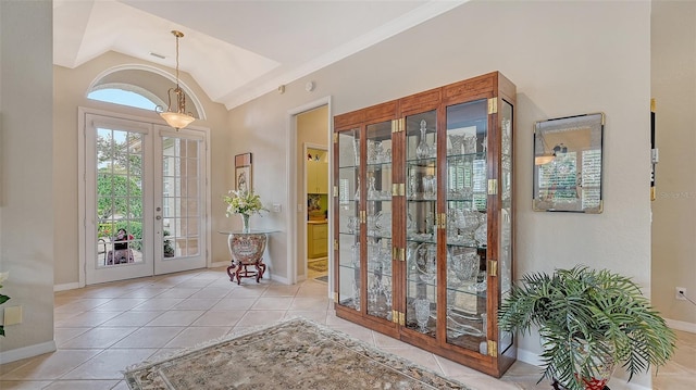 doorway with lofted ceiling, light tile patterned flooring, visible vents, baseboards, and french doors