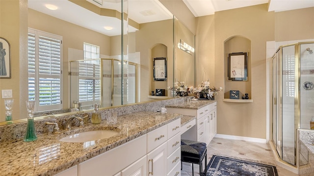 bathroom featuring tile patterned flooring, a shower stall, vanity, and baseboards