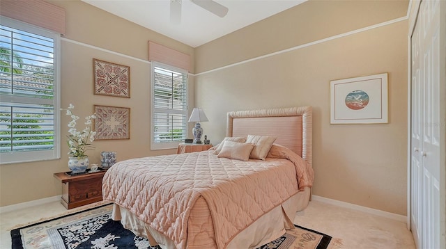 carpeted bedroom with baseboards and a ceiling fan