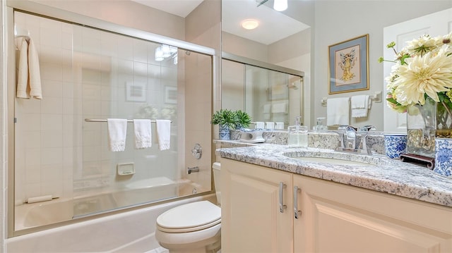 full bathroom with shower / bath combination with glass door, vanity, and toilet