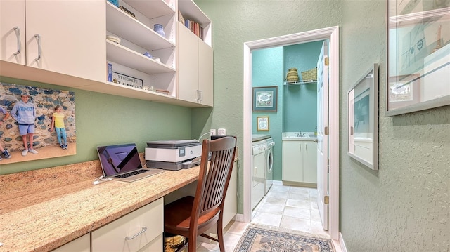 home office featuring a textured wall, built in desk, a sink, and washer / dryer