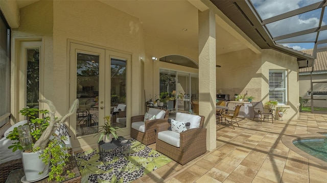 view of patio featuring glass enclosure and french doors