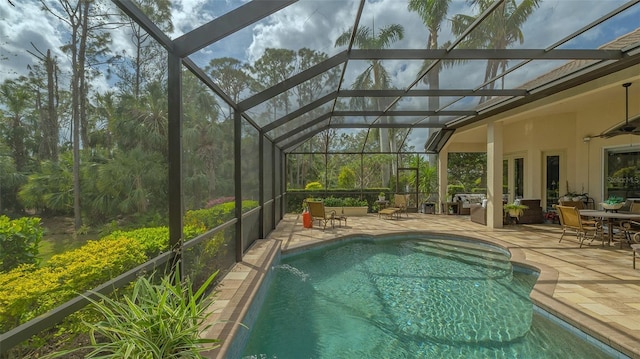 outdoor pool with a patio area, a lanai, and a ceiling fan