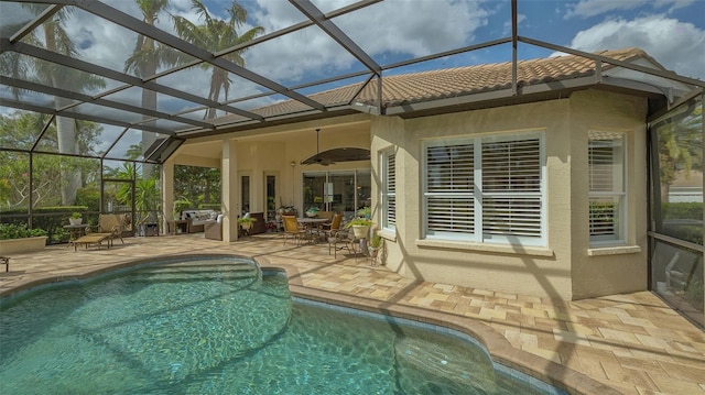 outdoor pool with ceiling fan, a patio, and a lanai