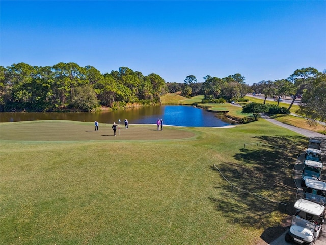 surrounding community with a lawn, a water view, and golf course view